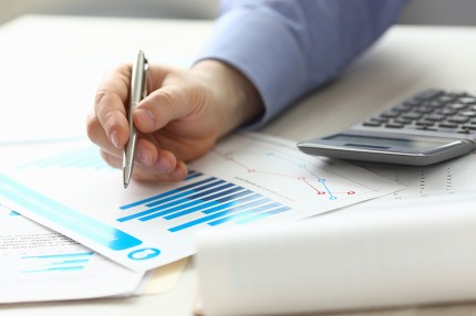 Person zeigt mit Stift auf Akten